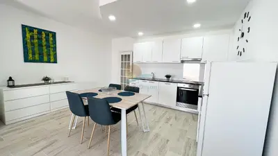 a kitchen with a table and chairs in a room at Alta Oura Prime by Sunny Deluxe in Albufeira