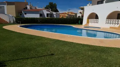 a swimming pool in a yard next to a house at Alta Oura Prime by Sunny Deluxe in Albufeira