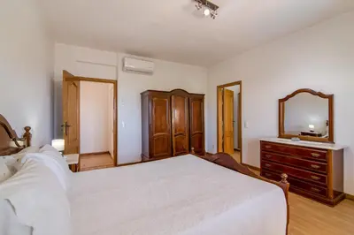 a bedroom with a bed and a dresser and a mirror at Villa do Lago in Albufeira