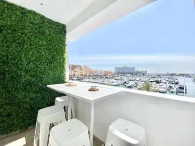 a balcony with a white bar with a view of a harbor at Mira Marina - Vilamoura in Vilamoura