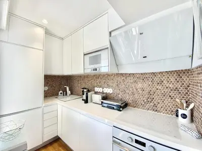 a white kitchen with white cabinets and appliances at Mira Marina - Vilamoura in Vilamoura