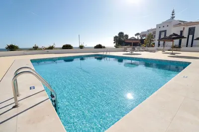 a large swimming pool with blue water at Olhos De Água 1BR with Pool, AC and Free Parking in Albufeira