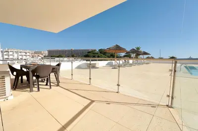 a patio with a table and chairs on a balcony at Olhos De Água 1BR with Pool, AC and Free Parking in Albufeira