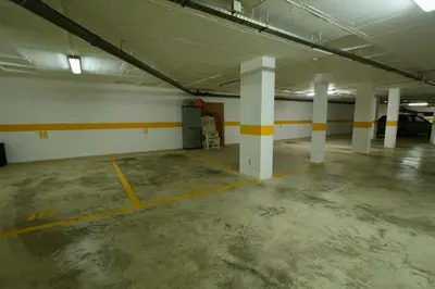 an empty parking garage with white and yellow columns at Olhos De Água 1BR with Pool, AC and Free Parking in Albufeira