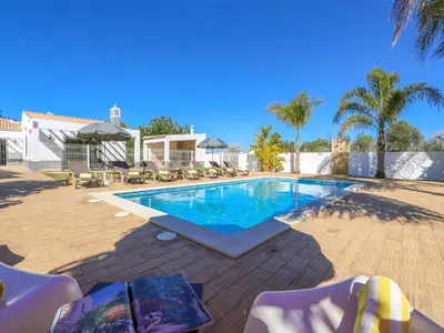a swimming pool in a yard with chairs and trees at Stunning Luxury Villa Private Pool, Galé Albufeira in Albufeira
