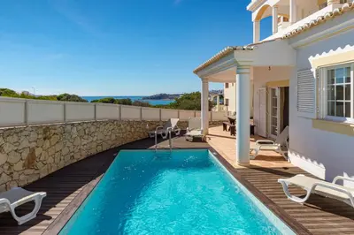 a villa with a swimming pool and a house at Villa Cecília in Albufeira