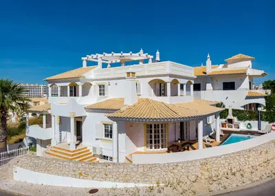 a large white house with a swimming pool at Villa Cecília in Albufeira