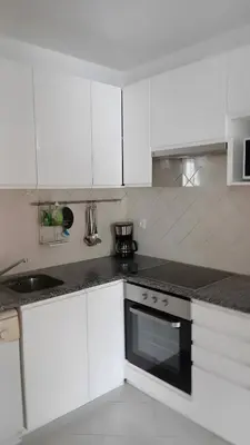 a kitchen with white cabinets and a stove top oven at Apartamento no Clube Praia da Oura in Albufeira