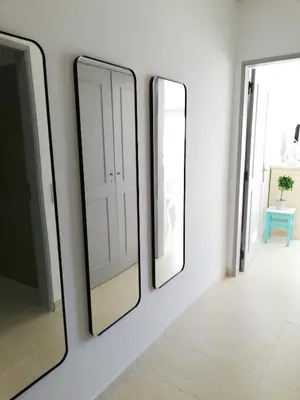 two mirrors on a white wall in a hallway at Praia Mar in Quarteira