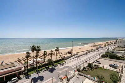 a view of a beach with palm trees and the ocean at Praia Mar in Quarteira