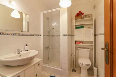 a bathroom with a shower and a toilet and a sink at Casa do Algarve in Albufeira