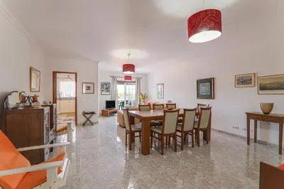 a dining room and living room with a table and chairs at Casa do Algarve in Albufeira