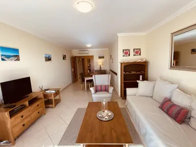 a living room with a white couch and a tv at Vista by Check-in Portugal in Albufeira