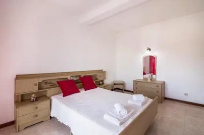 a bedroom with a large bed with red pillows at Casa Guerreiro in Branqueira