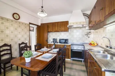 a kitchen with a wooden table and a dining room at Casa Guerreiro in Branqueira