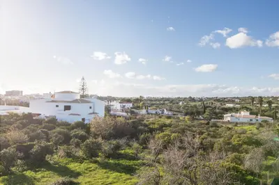 a view of a white building on a hill with trees at Casa Guerreiro in Branqueira