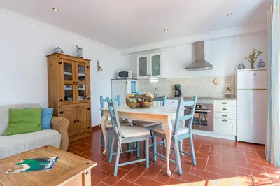 a kitchen and dining room with a table and chairs at Casa Mimao in Albufeira