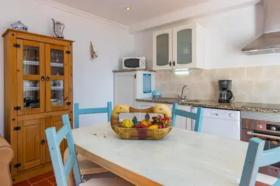 a kitchen with a table with a basket of fruit at Casa Mimao in Albufeira
