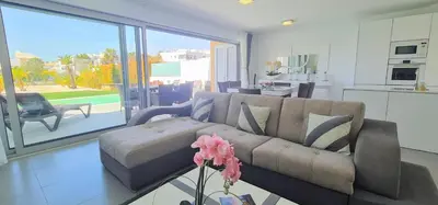 a living room with a couch and a kitchen at Villa Modern Design in Albufeira
