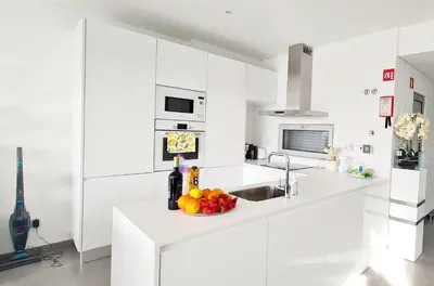 a white kitchen with a bowl of fruit on a counter at Villa Modern Design in Albufeira