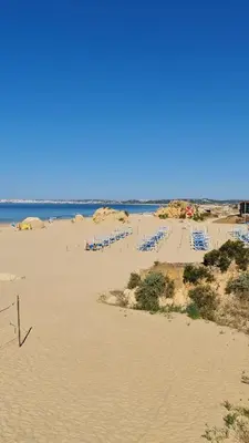 a sandy beach with blue chairs and the ocean at Villa Modern Design in Albufeira