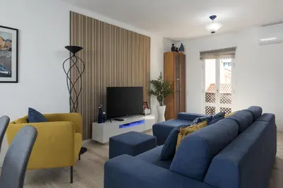 a living room with two blue couches and a tv at Marina Pearl - View to Vilamoura Marina in Vilamoura
