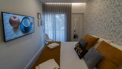 a room with a bed and a tv on a wall at Plan Be GuestHouse in Faro