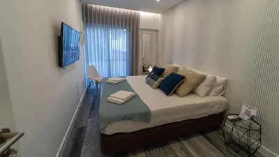 a bedroom with a bed with pillows and a window at Plan Be GuestHouse in Faro