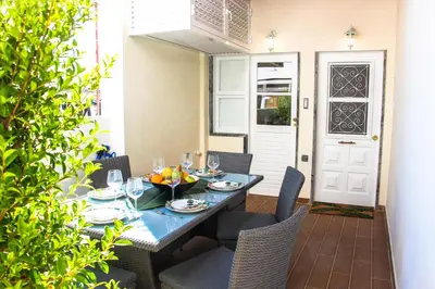 a dining table with chairs and a blue table and chairsktop at Apartamentos SweetHomes in Faro