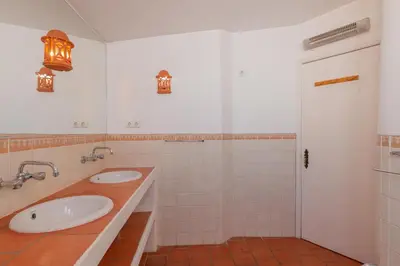 a white bathroom with two sinks and a shower at Oura Family House in Albufeira