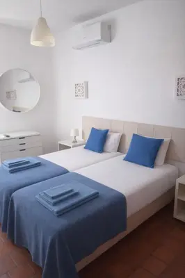 two beds in a room with blue pillows on them at Oura Family House in Albufeira