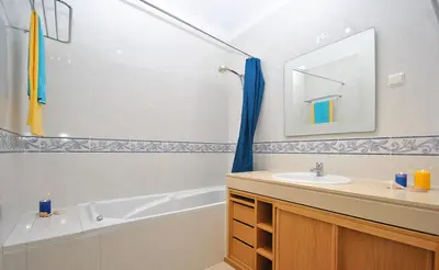 a bathroom with a sink and a tub and a mirror at Apartment Orlando by Algarve Vacation in Albufeira