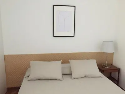 a bed with two pillows and a picture on the wall at Tossan House in Vilamoura Downtown in Quarteira