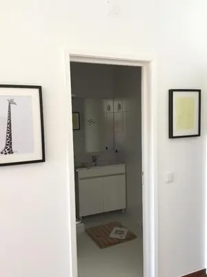 a white bathroom with a sink and a mirror at Tossan House in Vilamoura Downtown in Quarteira