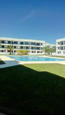 a large apartment building with a large swimming pool at Tossan House in Vilamoura Downtown in Quarteira