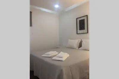 a white bedroom with a bed with two towels on it at Marina Mar in Vilamoura downtown in Quarteira