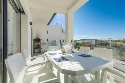 a white dining room with a white table and white chairs at Correeira Luxury Residence in Albufeira