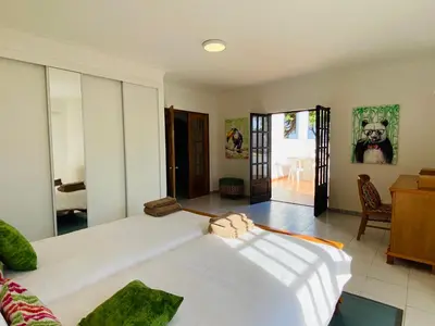 a bedroom with two beds and a door to a patio at Azinheira by Check-in Portugal in Albufeira
