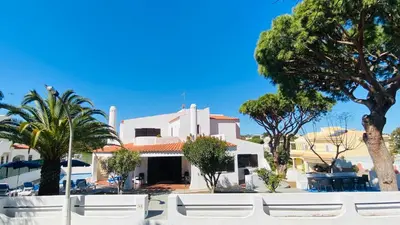 a white house with palm trees in front of it at Azinheira by Check-in Portugal in Albufeira