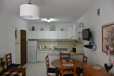 a kitchen with a table and a dining room at Apartamentos Encosta do Mar in Albufeira