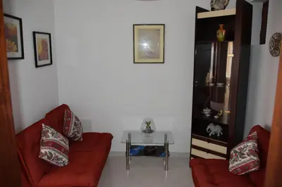 a living room with two red couches and a table at Apartamentos Encosta do Mar in Albufeira
