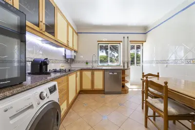 a kitchen with a washer and dryer in a room at Villa Moises in Albufeira