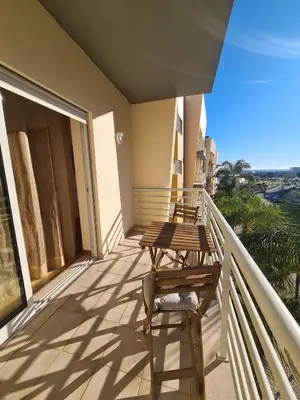 a balcony with wooden tables and chairs on it at Vilamoura, Moura Praia in Quarteira
