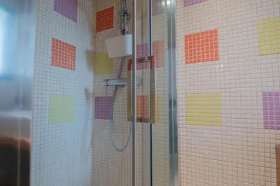 a bathroom with a shower with colorful tiles at Coastal Retreat with Pool and Beach Access by Drago Rentals in Albufeira