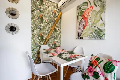 a dining room with a white table and chairs at Cosy by the pool in Quarteira