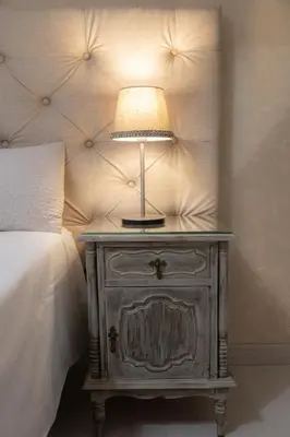 a lamp on a night stand next to a bed at Bambus House Blue in Quarteira