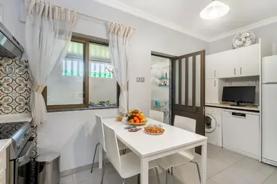 a kitchen with a white table and a white table and chairs at Bambus House Blue in Quarteira