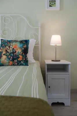 a bed with a pillow and a lamp on a night stand at Bambus House Green in Quarteira
