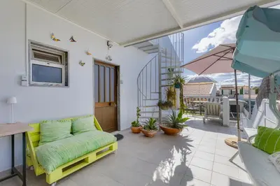 a living room with a green couch on a balcony at Bambus House Green in Quarteira