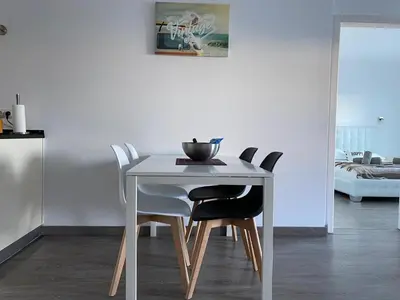 a dining room table with a white table and chairs at Deluxe apartment in Albufeira old town, 200m walk to beach, pool parking in Albufeira